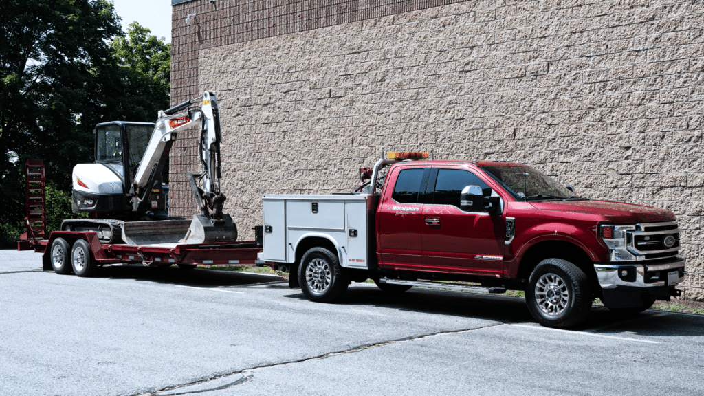Monsignore Excavating service truck hooked up to a trailer with an excavator.