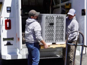Mommens Heating And Cooling Field Techs Unloading Central Air Unit From Kuv Van Cargo Area
