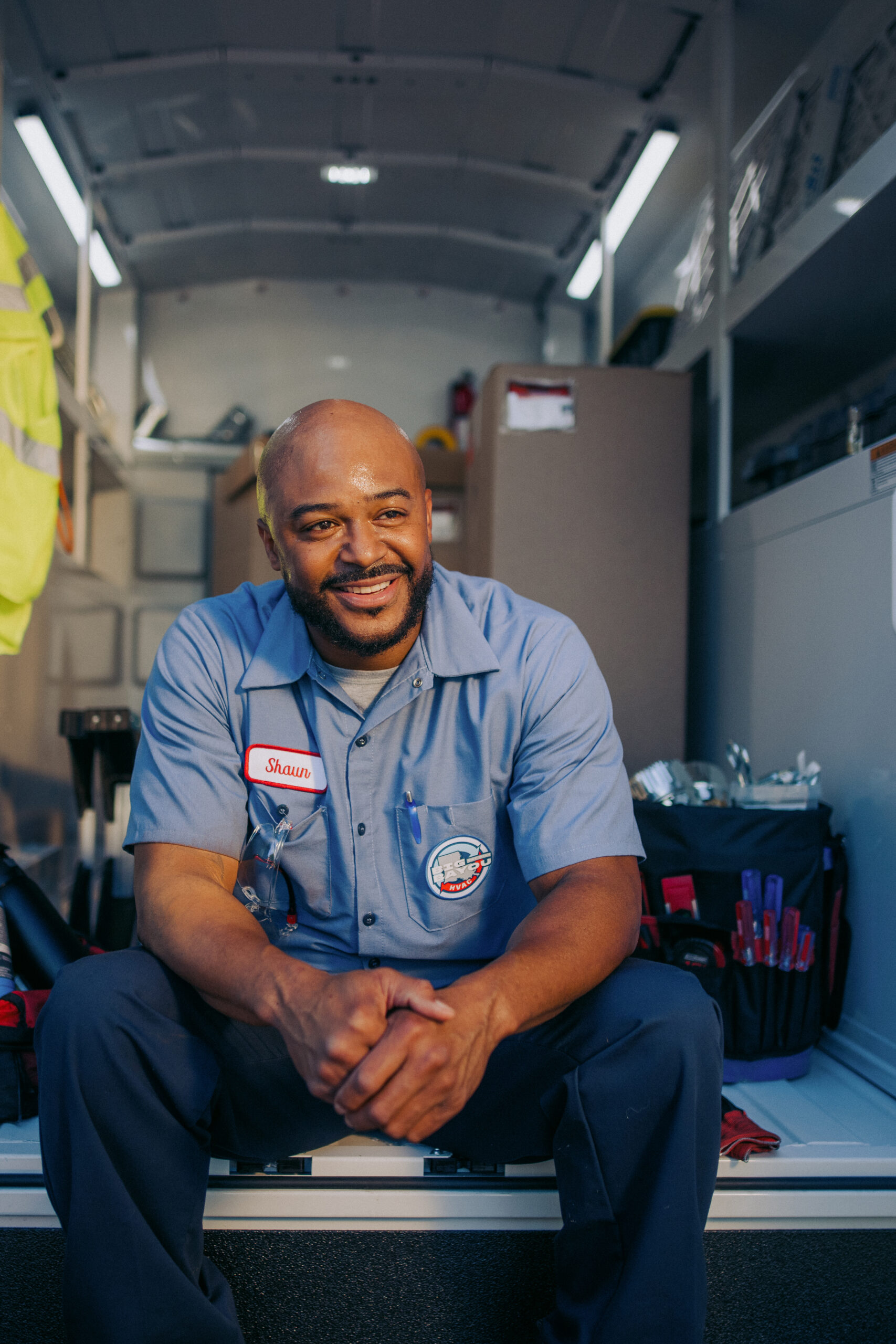 Shaun of Big Bayou HVAC Smiling While Sitting in the Back of a Knapheide KUV Van