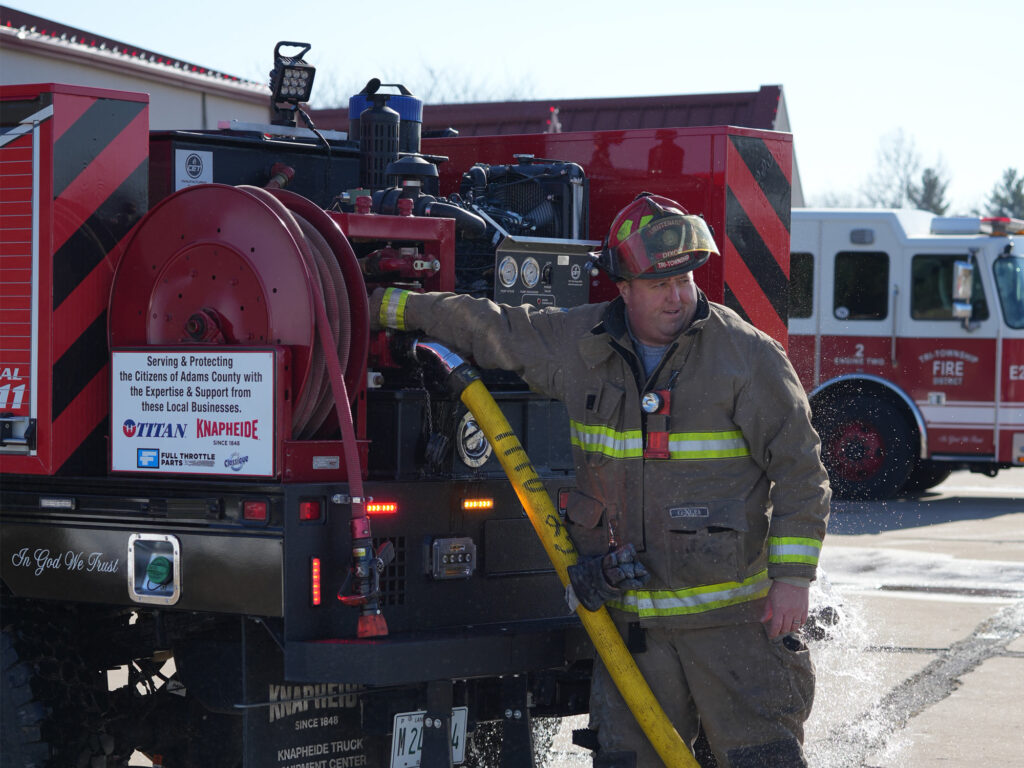 Tri-Township-Fire-Department-Firefighter-Operating-Water-Pump-System-On-Knapheide-Brush-Truck