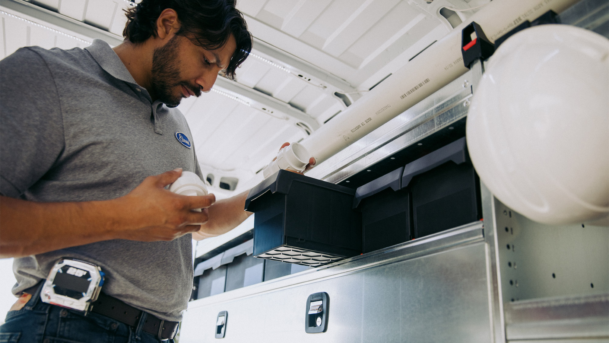 Service-Professional-Grabbing-Supplies-from-Bin-on-Shelving-of-Knapheide-Upfitted-Cargo-Van