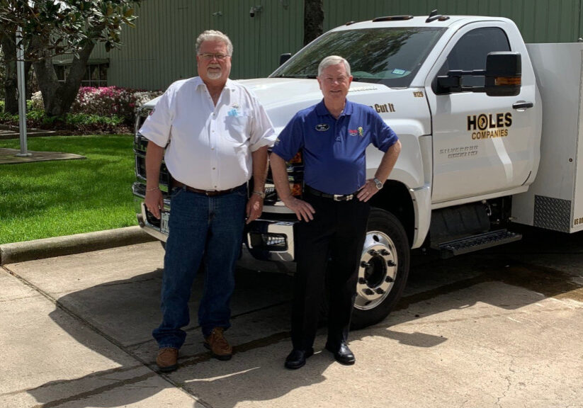 holes inc owners standing by knapheide saw truck