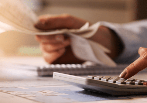 Closeup Economist Using Calculator While Going Through Bills Taxes Office