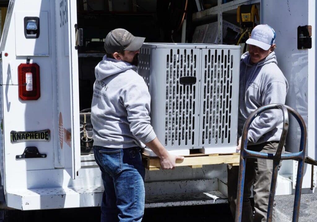 Mommens Heating And Cooling Field Techs Unloading Central Air Unit From Kuv Van Cargo Area Treated